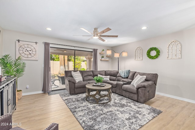 living room featuring light hardwood / wood-style flooring and ceiling fan