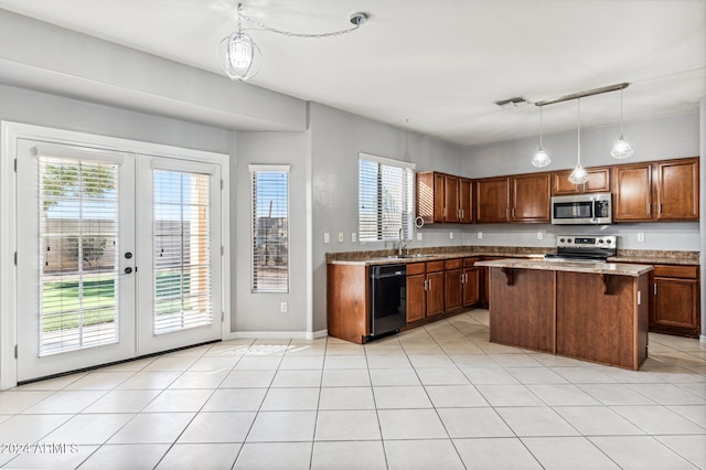 kitchen with french doors, a center island, pendant lighting, a kitchen bar, and appliances with stainless steel finishes