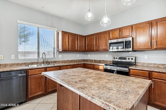 kitchen with light tile patterned flooring, sink, appliances with stainless steel finishes, decorative light fixtures, and a kitchen island