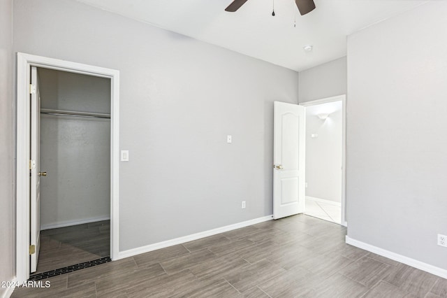 unfurnished bedroom with hardwood / wood-style flooring, ceiling fan, and a closet