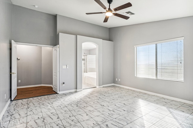 unfurnished bedroom featuring ceiling fan and ensuite bath