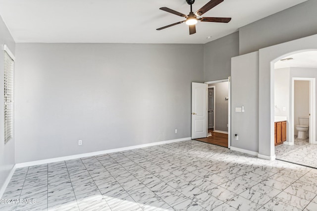 unfurnished bedroom with ensuite bathroom, vaulted ceiling, and ceiling fan