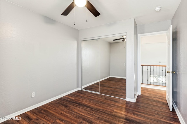 unfurnished bedroom featuring ceiling fan, a closet, and dark wood-type flooring