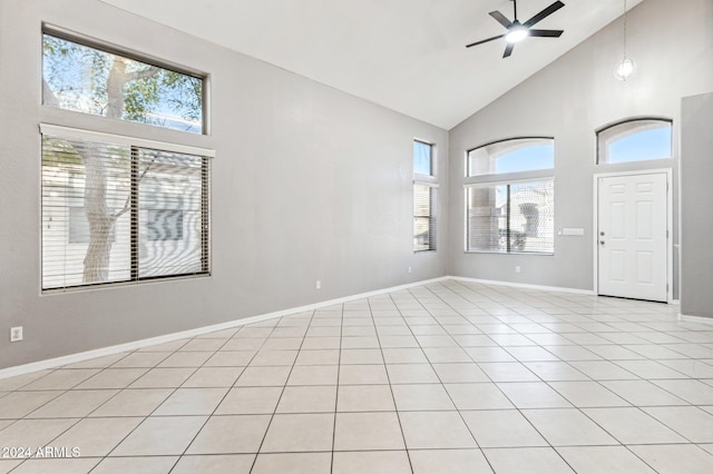 tiled spare room featuring high vaulted ceiling, plenty of natural light, and ceiling fan