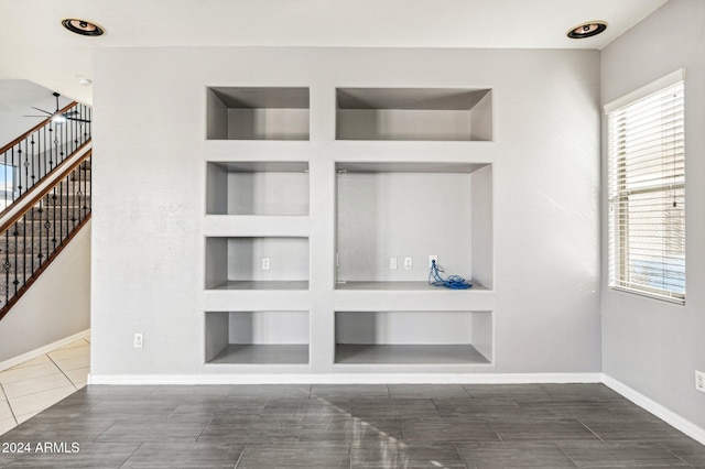 interior space with built in shelves and ceiling fan