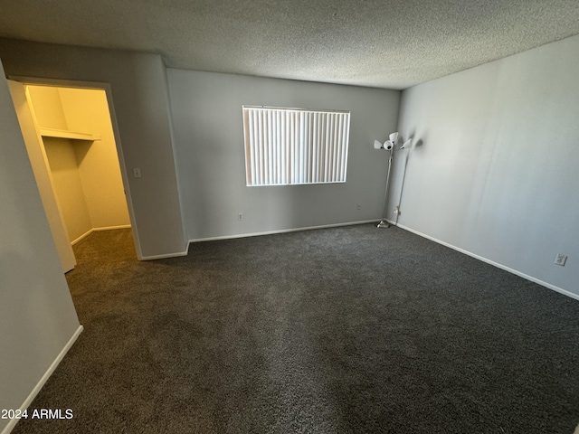 carpeted spare room with a textured ceiling