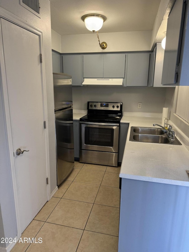 kitchen featuring gray cabinets, sink, light tile patterned flooring, and stainless steel appliances