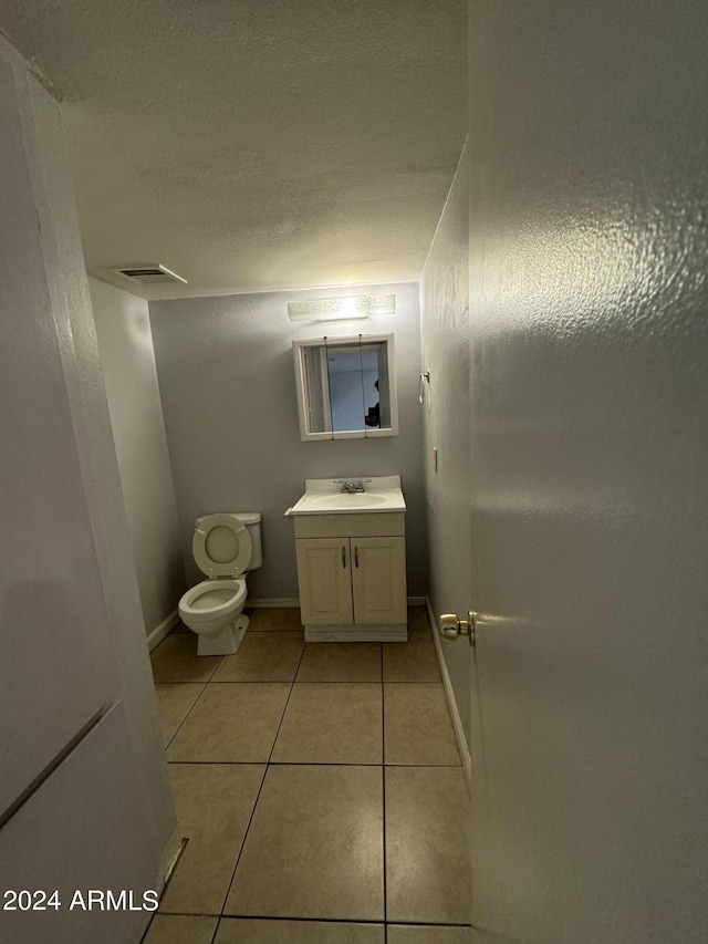 bathroom with vanity, toilet, and tile patterned floors