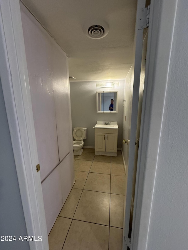 bathroom featuring vanity, toilet, and tile patterned flooring