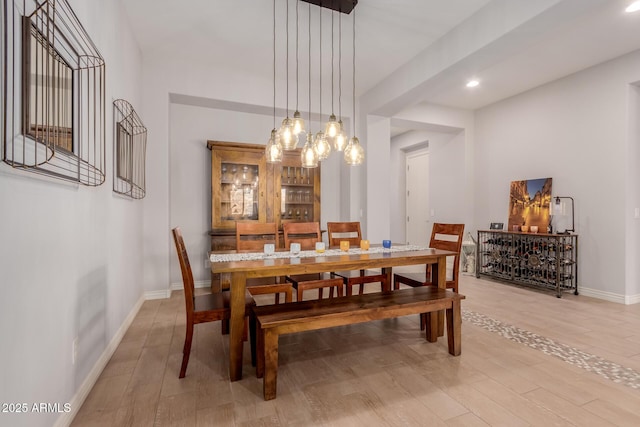 dining room featuring baseboards, recessed lighting, light wood-style flooring, and an inviting chandelier