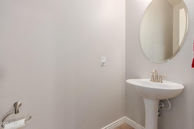 bathroom with baseboards and a sink