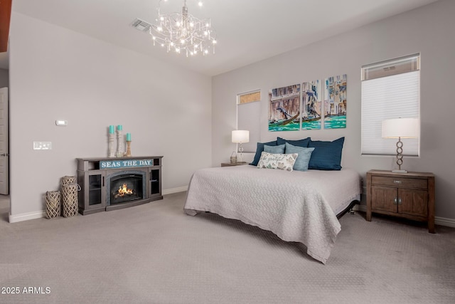 carpeted bedroom featuring an inviting chandelier, baseboards, and visible vents