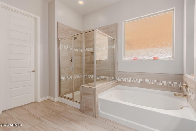 full bath with a stall shower and a garden tub