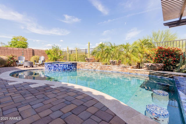 view of swimming pool featuring a fenced backyard, a patio area, and a pool with connected hot tub