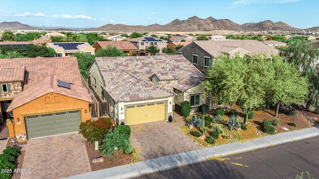 view of front of house with a residential view, a garage, stucco siding, a mountain view, and driveway