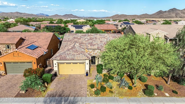 view of front of house with an attached garage, driveway, and a mountain view