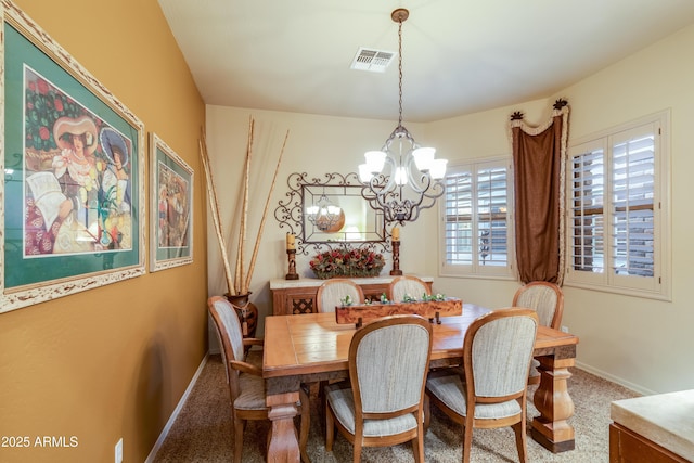 carpeted dining area featuring a chandelier