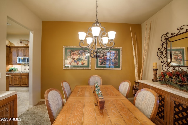 dining room featuring a notable chandelier and light tile patterned flooring