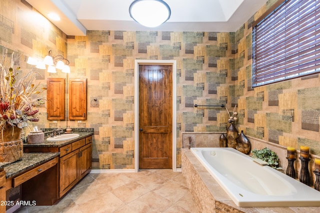 bathroom with tile patterned flooring, vanity, and a relaxing tiled tub