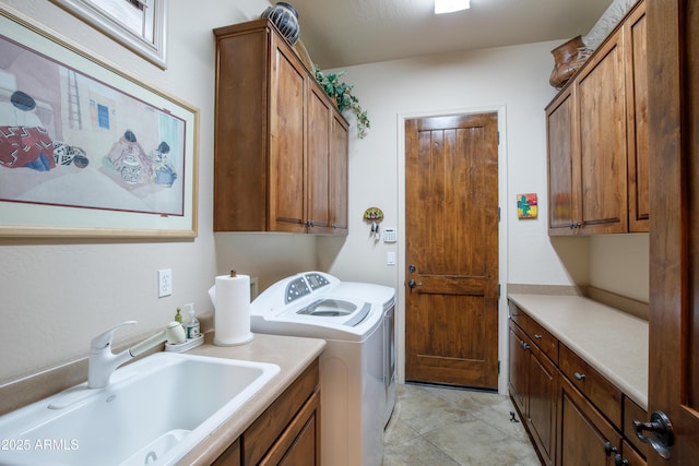 washroom with washing machine and clothes dryer, sink, and cabinets