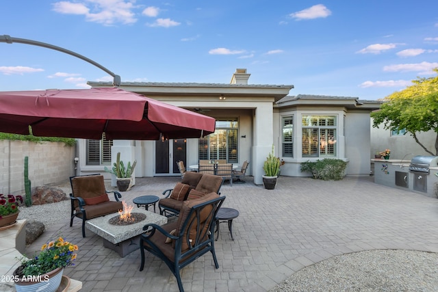 view of patio / terrace featuring an outdoor fire pit, exterior kitchen, and a grill