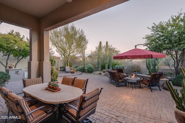 patio terrace at dusk featuring a fire pit