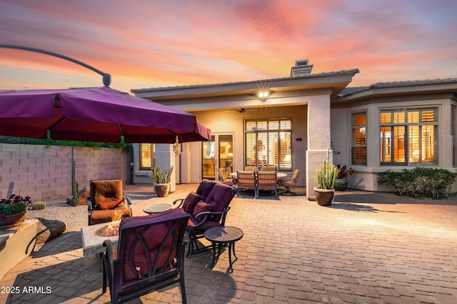 back house at dusk featuring an outdoor living space and a patio