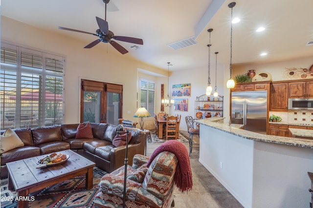 living room with ceiling fan with notable chandelier