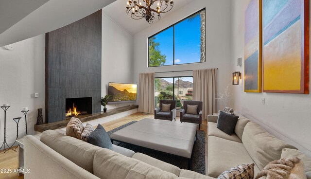4824 E Hummingbird Ln, Paradise Valley, AZ 85253 - living area featuring high vaulted ceiling, light wood finished floors, a chandelier, and a tile fireplace