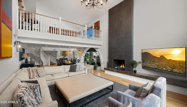 4824 E Hummingbird Ln, Paradise Valley, AZ 85253 - living area with wood finished floors, a chandelier, a high ceiling, a large fireplace, and stairs
