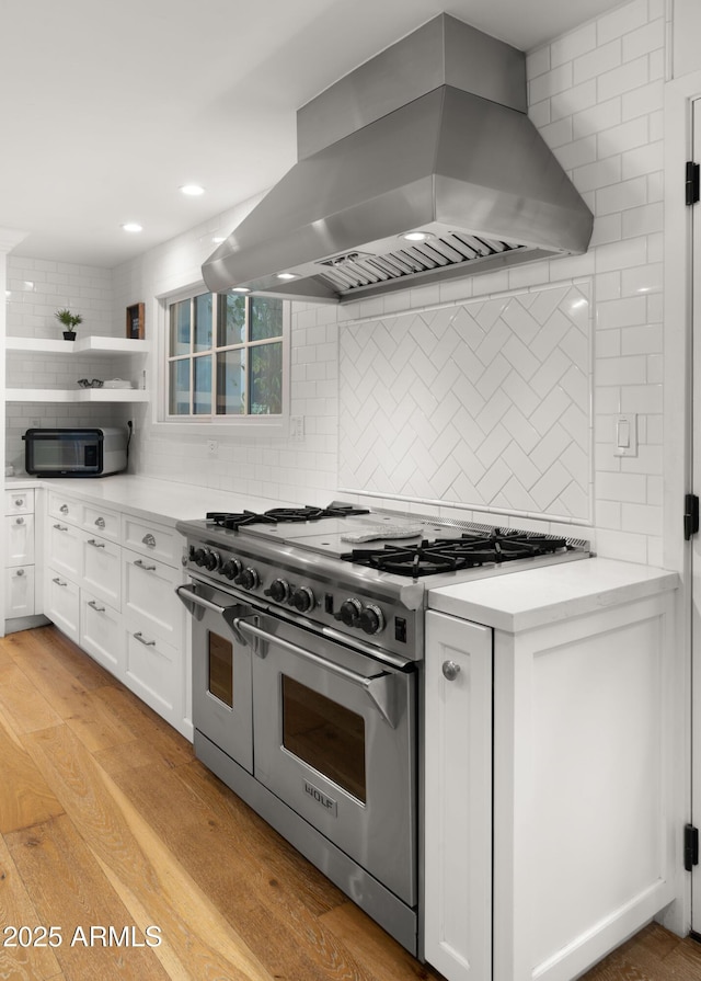 4824 E Hummingbird Ln, Paradise Valley, AZ 85253 - kitchen featuring range with two ovens, island exhaust hood, decorative backsplash, white cabinets, and recessed lighting