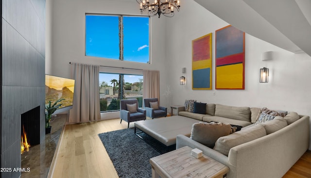 4824 E Hummingbird Ln, Paradise Valley, AZ 85253 - living room with a chandelier, a towering ceiling, wood finished floors, and a fireplace