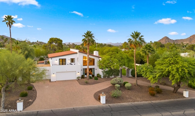 4824 E Hummingbird Ln, Paradise Valley, AZ 85253 - view of front of home with a balcony, decorative driveway, a garage, a mountain view, and stucco siding