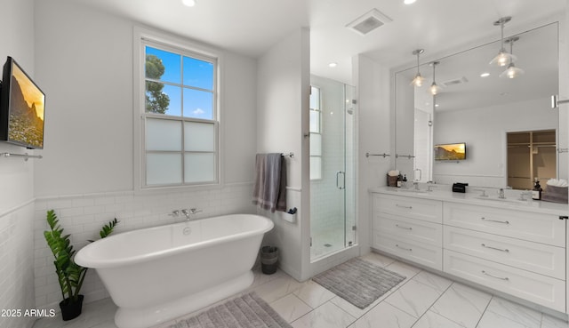 4824 E Hummingbird Ln, Paradise Valley, AZ 85253 - full bathroom with double vanity, a shower stall, a soaking tub, recessed lighting, and wainscoting