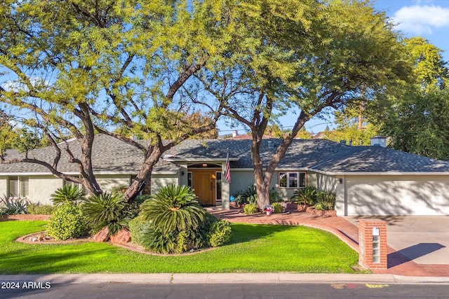 view of front of property with a garage and a front lawn