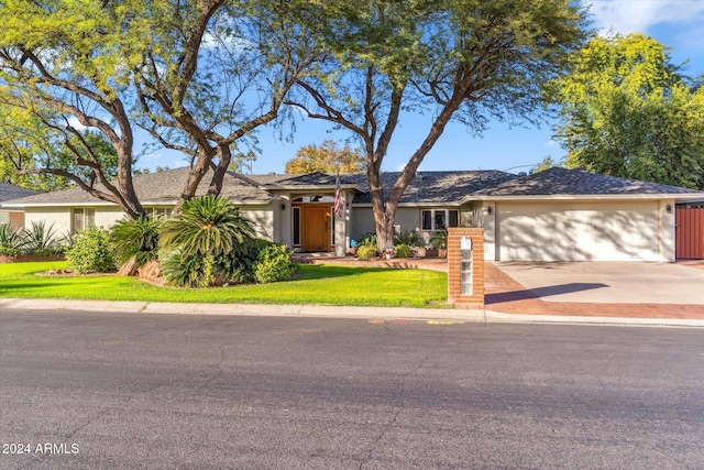 ranch-style house with a front yard and a garage