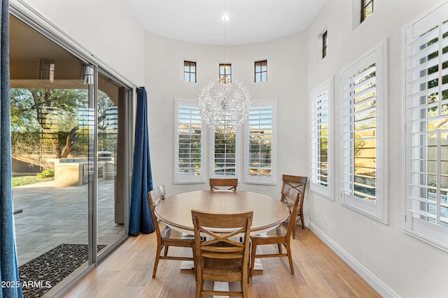 dining space with a notable chandelier and light hardwood / wood-style floors