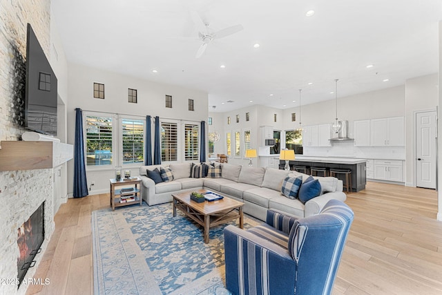 living room with a wealth of natural light, a fireplace, and light wood-type flooring