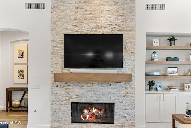 room details featuring a stone fireplace and hardwood / wood-style floors