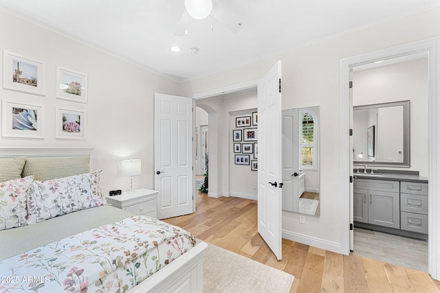 bedroom featuring crown molding, ensuite bathroom, and light hardwood / wood-style floors