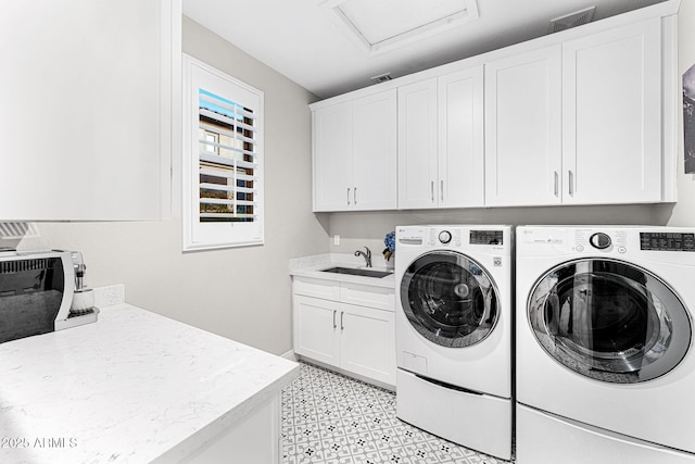 clothes washing area featuring cabinets, sink, and washing machine and clothes dryer