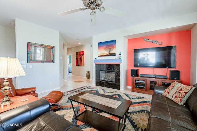 tiled living room with ceiling fan and a fireplace