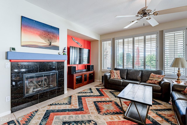 tiled living room with ceiling fan and a fireplace