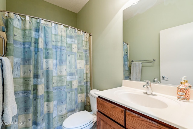 bathroom featuring vanity, toilet, and a textured ceiling