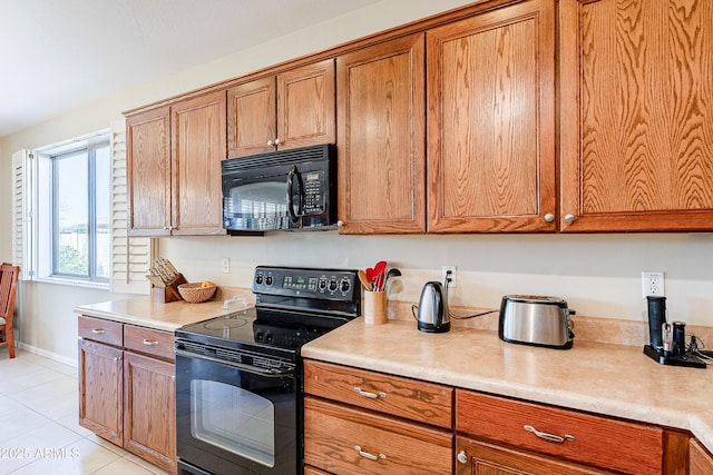 kitchen featuring light tile patterned flooring and black appliances