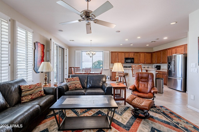 tiled living room featuring ceiling fan with notable chandelier