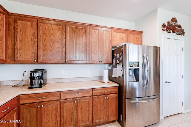 kitchen featuring stainless steel refrigerator with ice dispenser and light tile patterned floors