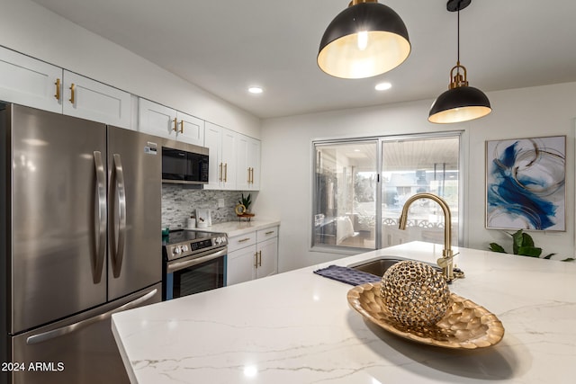 kitchen featuring light stone counters, appliances with stainless steel finishes, and white cabinets