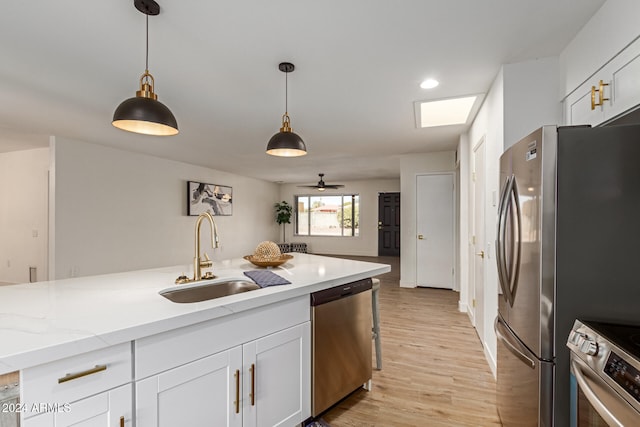 kitchen with white cabinetry, appliances with stainless steel finishes, sink, and hanging light fixtures