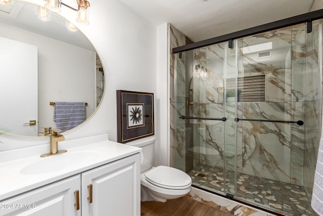 bathroom featuring toilet, vanity, wood-type flooring, and a shower with door